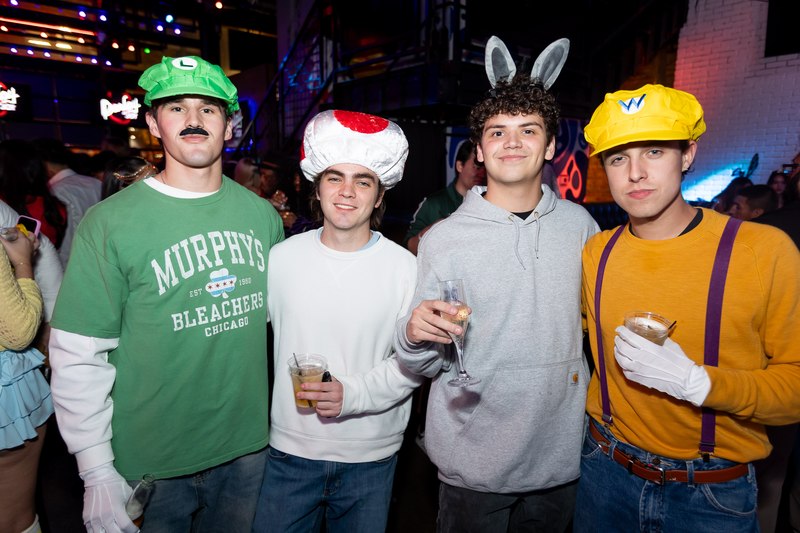 A group of friends in costume holding drinks at Crawlloween