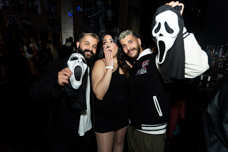 Attendees in horror masks posing at a Crawlloween venue