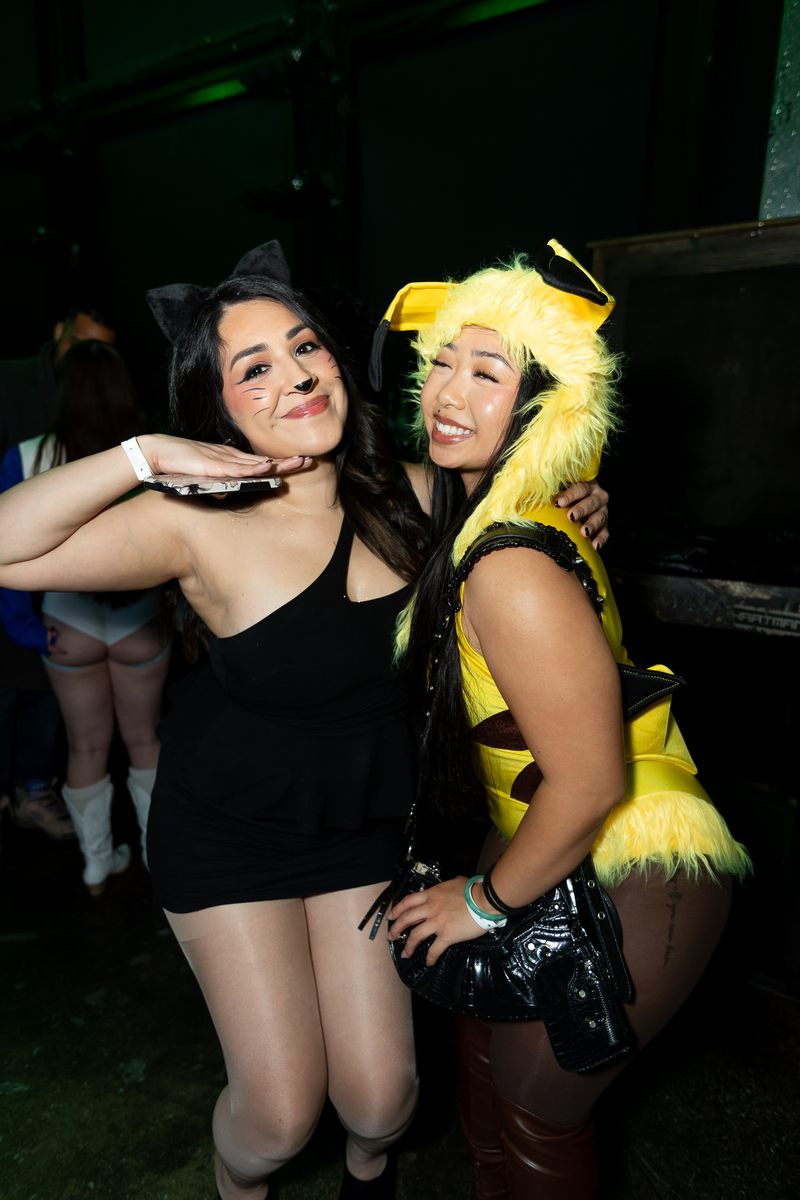 Two friends in costume posing together on Halloween night