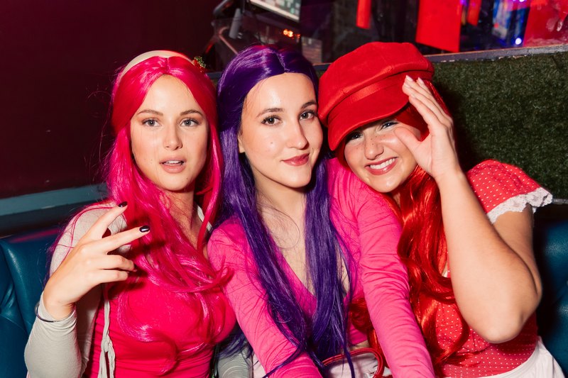 A group in bright wigs and costume at a Crawlloween stop