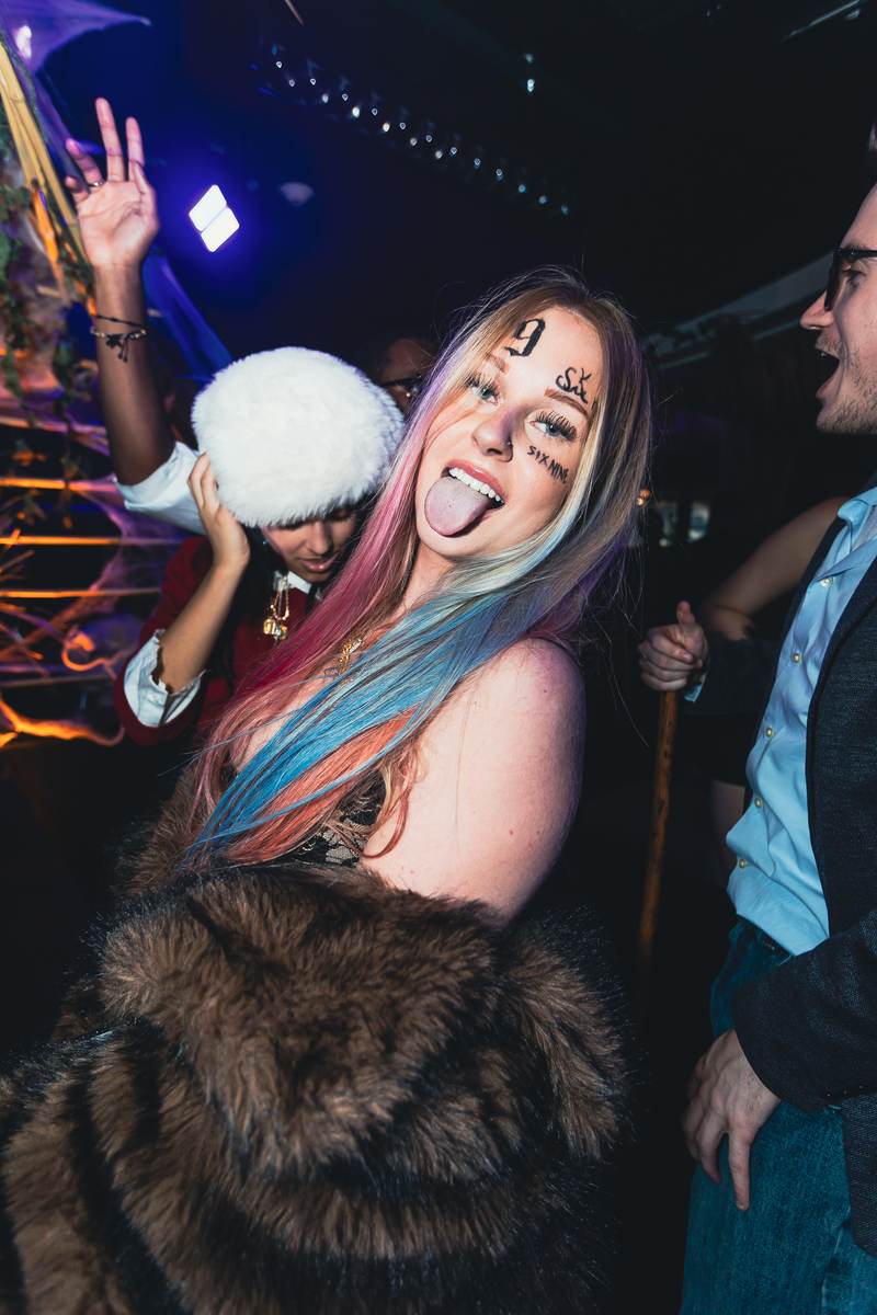 An attendee in full face paint on the dance floor