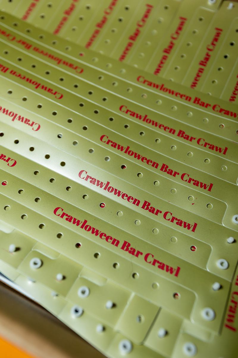 A printed sheet of Crawlloween Bar Crawl wristbands ready for check-in